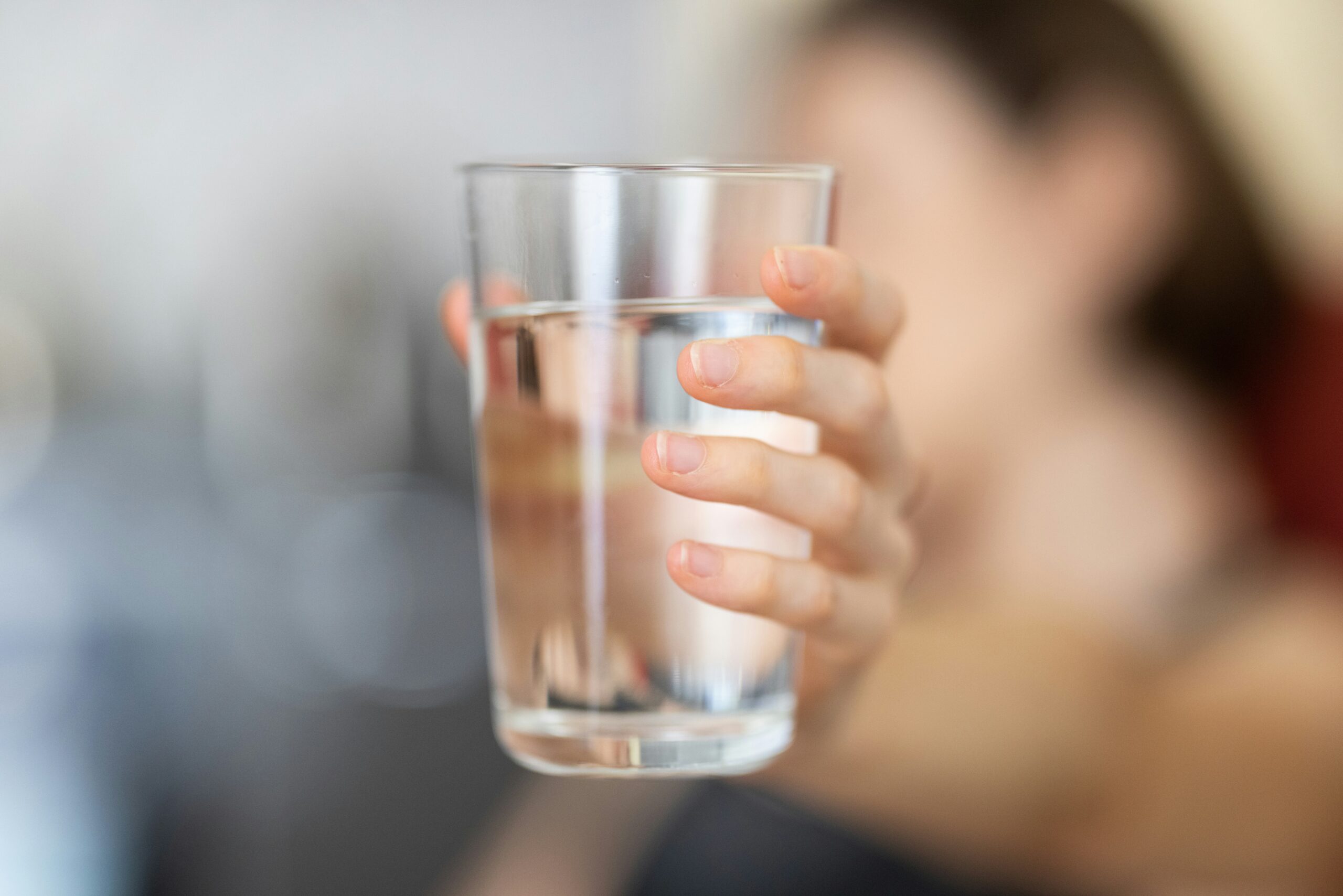 a girl holding a full glass of water